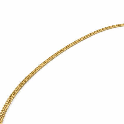 A close-up of a gold-colored braided chain, likely a necklace chain, shown against a plain white background.