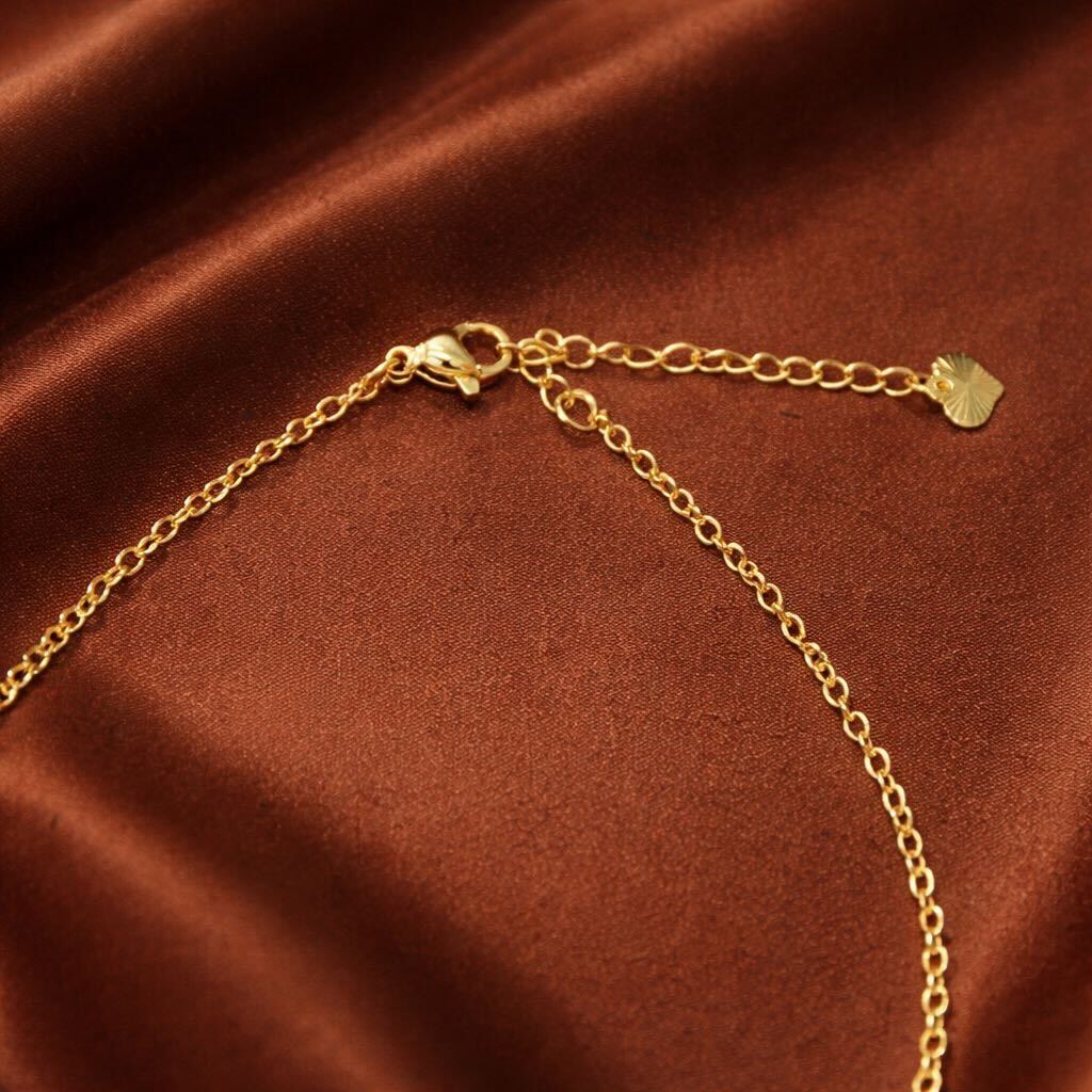 Gold chain bracelet on a brown satin background