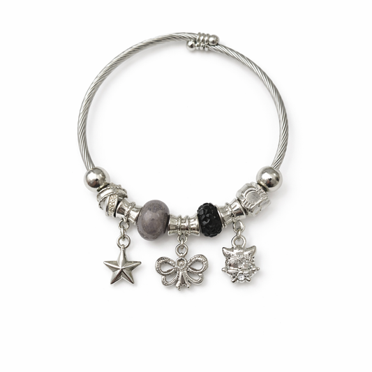 Silver charm bracelet with various charms on a white background